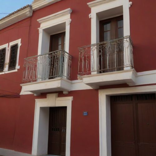 Fachada del hogar de una persona con pintura roja y blanca